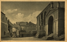 Gryf&oacute;w Śląski : na pierwszym planie wejście do kościoła, dalej domy na placu kościelnym