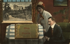 Głuchołazy : na pierwszym planie kobieta i mężczyzna przyglądający się leżącemu na stole albumowi „Album von Ziegenhals”, za oknem widok m.in. na sanatorium „Waldfrieden”